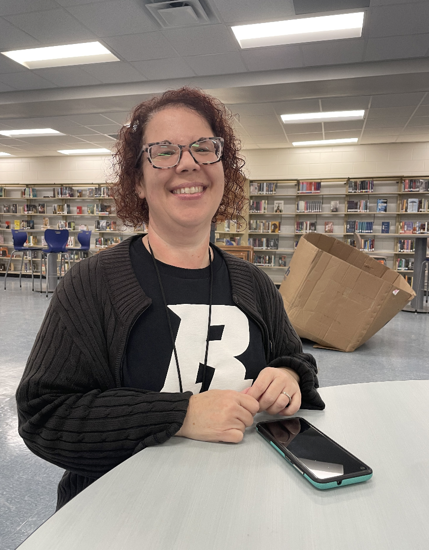 New media specialist, Shannon Chamberlain sits in the library smiling awaiting the new school year. 