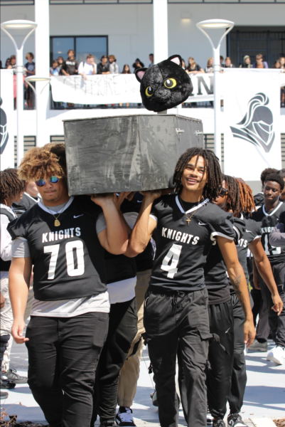 Jaydon Jackson (24) and Lakeem Johnson (24) walks down the courtyard with the Panther head on the casket. 
