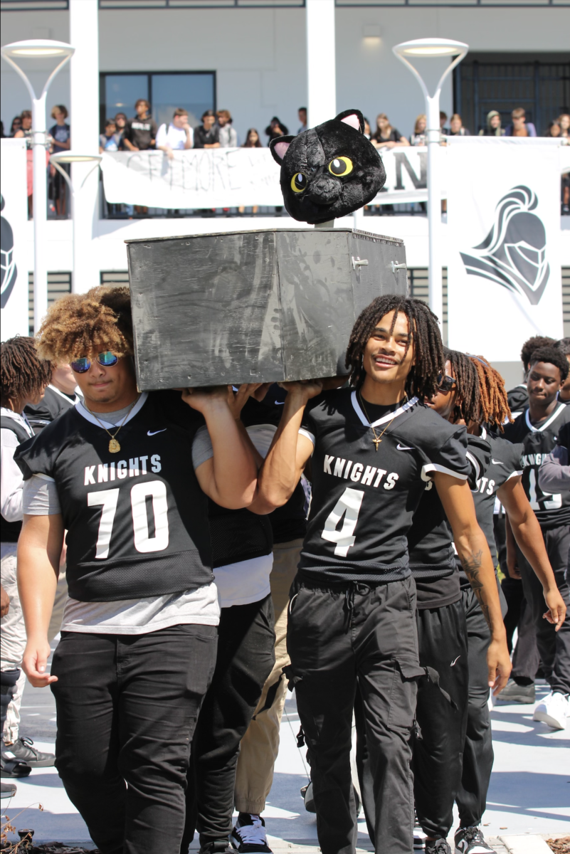 Jaydon Jackson (24) and Lakeem Johnson (24) walks down the courtyard with the Panther head on the casket. 
