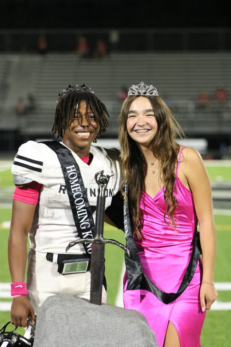 The 2023 Homecoming King and Queen, Wilton Rollins (24) and Madyson Carson (24), pose next to each other as they get ready to pull the sword. 