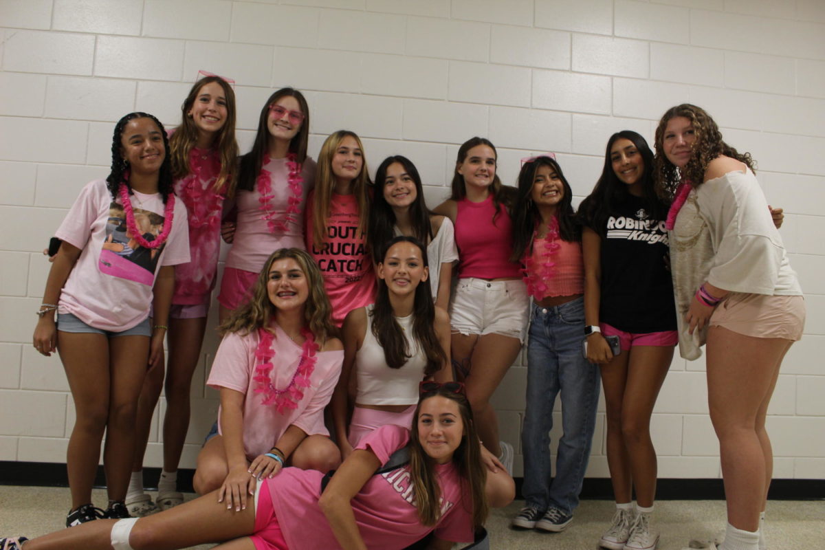 A group of freshmen girls pose in their pink attire on the final day of spirit day: Barbie Day. 