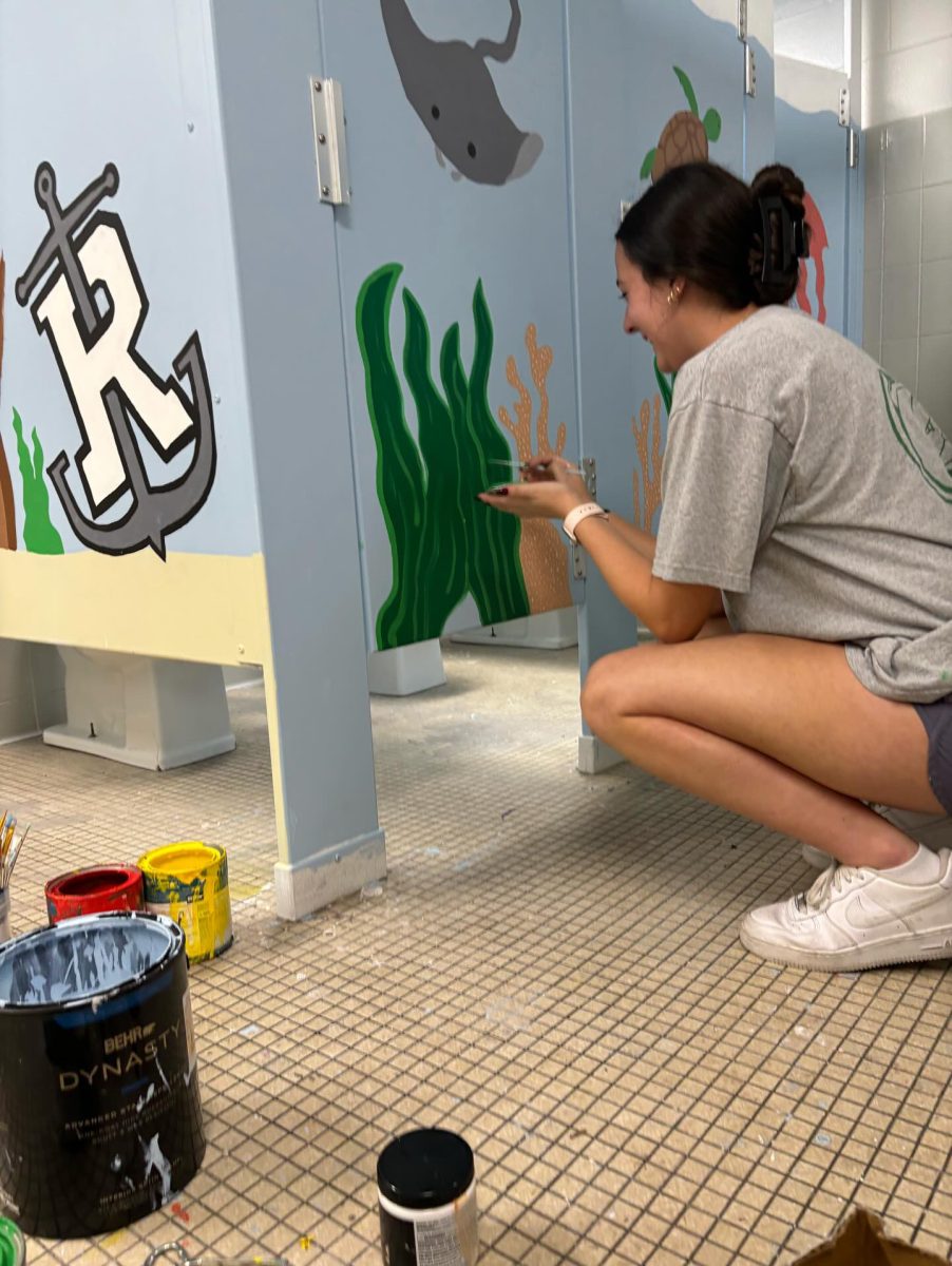 Mina Kuklen (24) adds details to kelp on the stalls of the womens restroom in the gym.