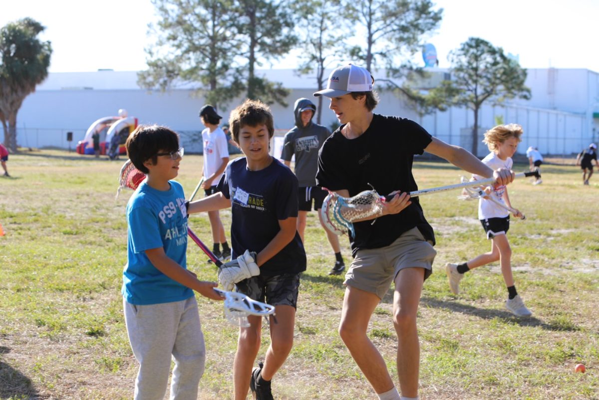 Kyler Courtermanch (‘26) shows young lacrosse players technique. 