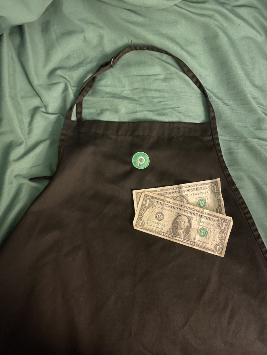  A Publix uniform with two dollars displayed.