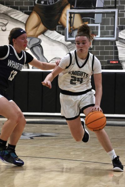 Jennie Gutman (25) dribbles the ball away from a Wharton defender.