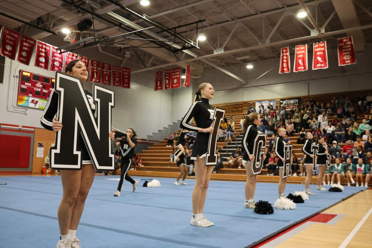 Line of cheerleaders hold letters that spell out K-N-I-G-H-T-S.