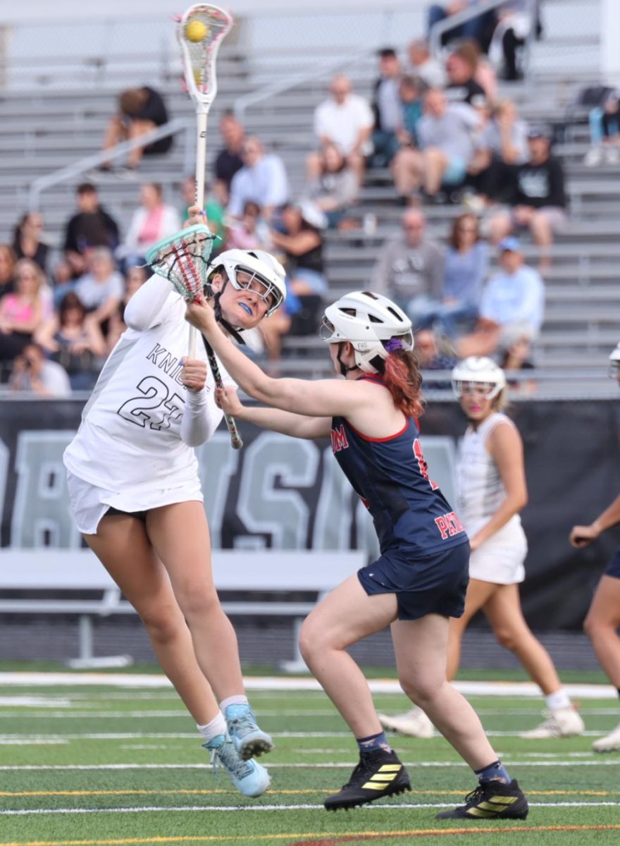 Jane Wyrick ('26) jumping, throwing the ball in for a goal. 