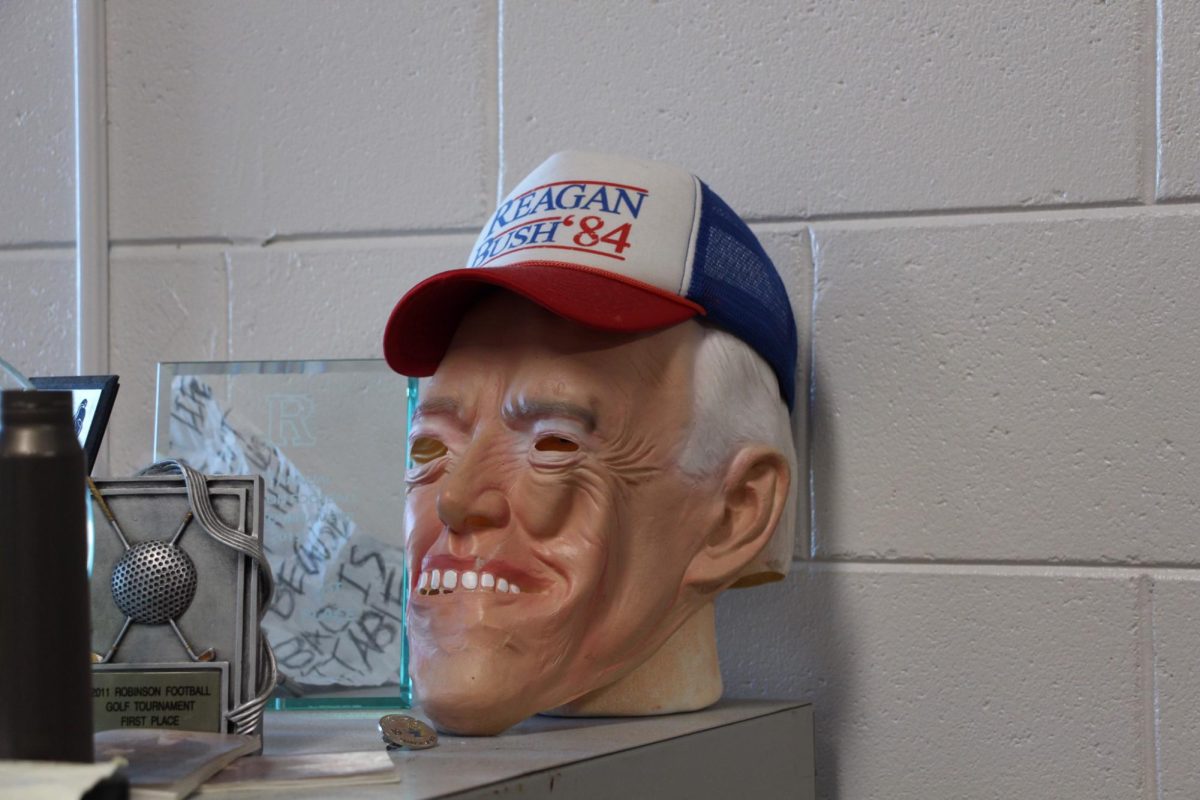 Political+mask+of+Biden+wearing+Reagan+Bush+hat+displayed+in+classroom+by+teacher.
