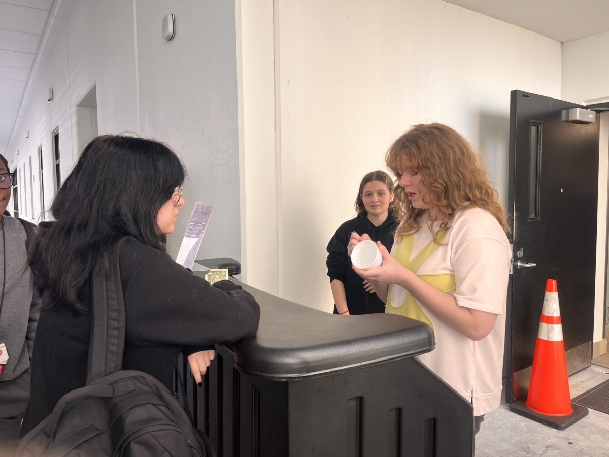 Kiersten Schreiber ('25) takes a student's order at the culinary coffee cart on its first day in business. 