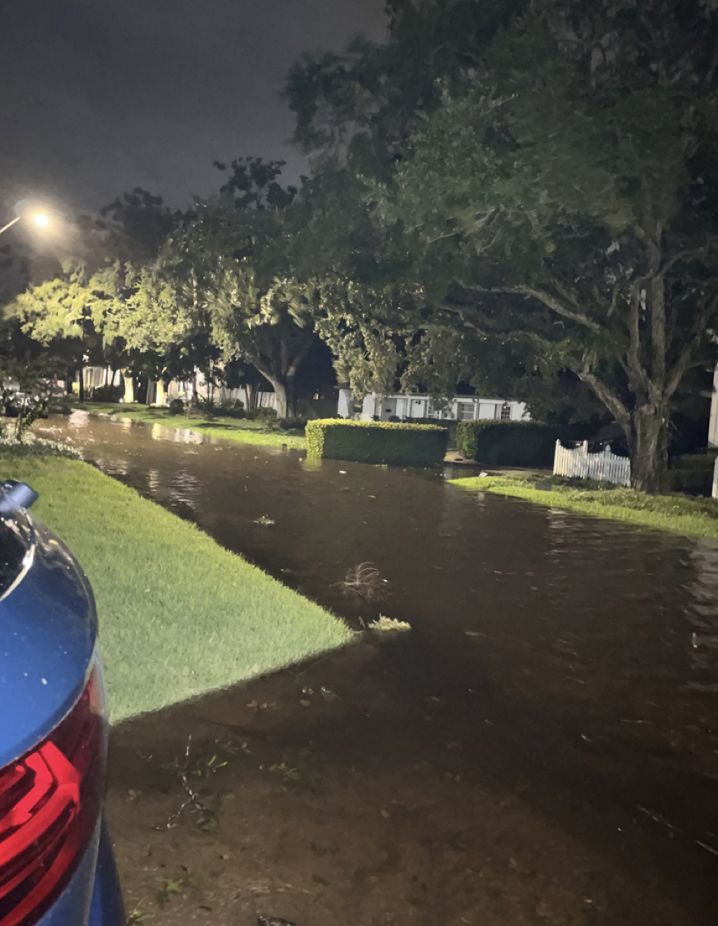 A residential street almost completely flooded after a downpour. 