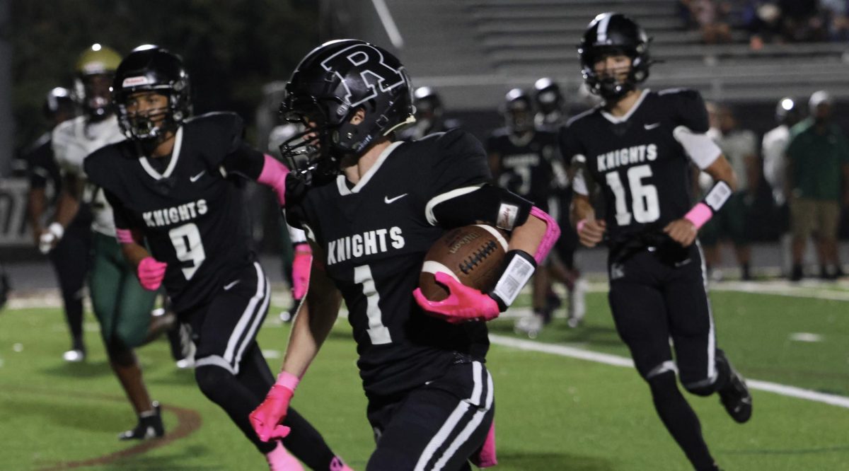 Xander Logan ('25) runs down the football field at an RHS home game.