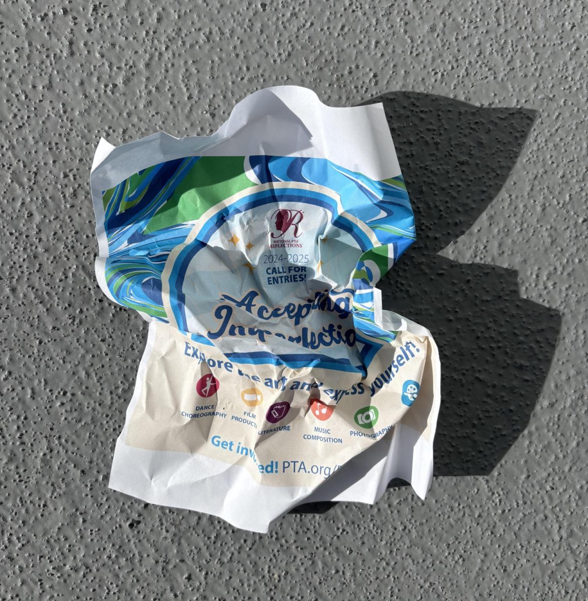 Photo of crumpled flyer promoting the art competition displays the student body's neglect towards the contest.