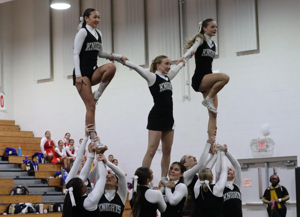 Maile Abell ('26), Laura Smith ('26) and Kateyn Boyd ('26) hit their pyramid during the Western Conference Qualifier.