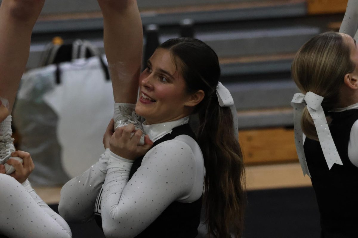 Senior and captain Maddie McCaulley supporting her teammate during the stunt to finish out their routine at the Western Conference Qualifying meet.  