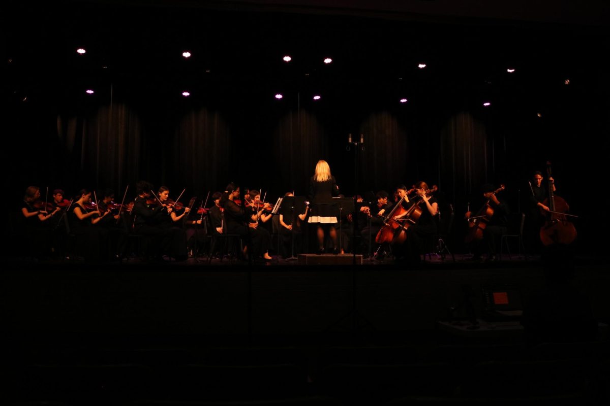 Mrs. Howard conducts the advanced orchestra.