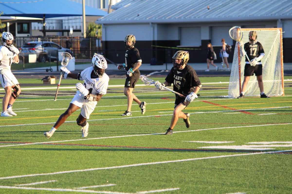 Midfielder Michael Jeffers ('25) running around Plant Panther defenders. 