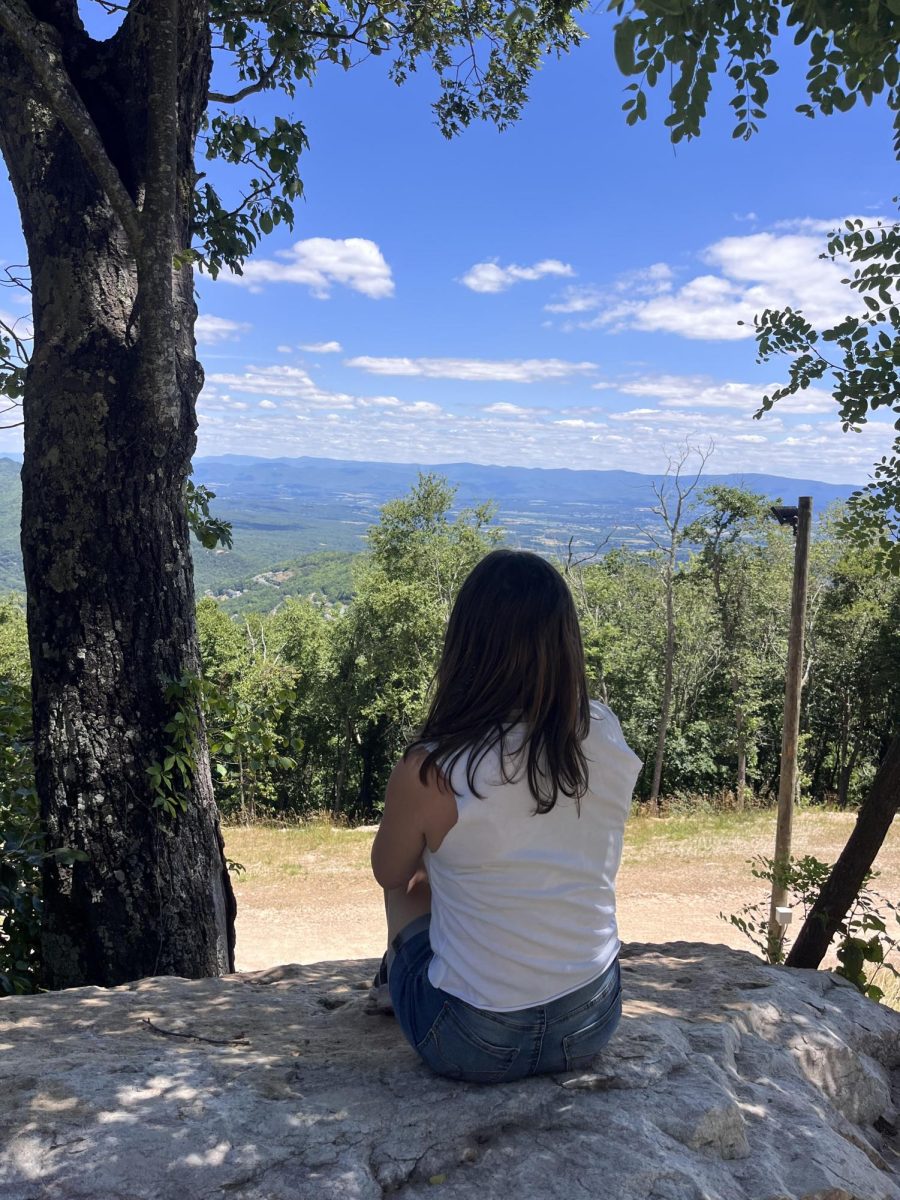 Aurora Bartholomay ('26) sits in front of mountains on past spring break trip.