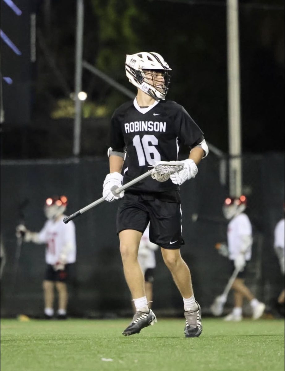 Amir Hosni ('27) running on the lacrosse field.