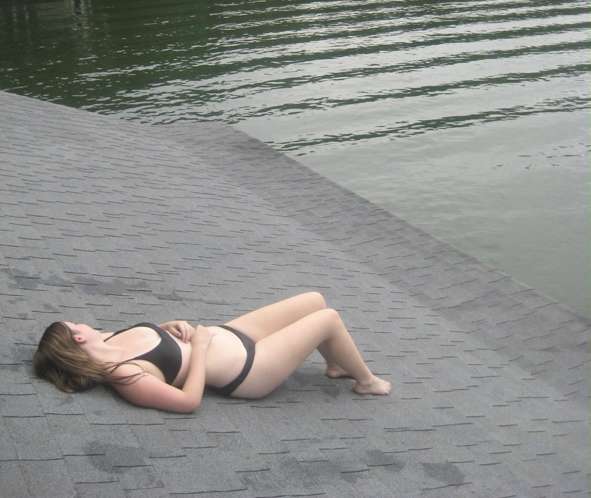 Ryan Rolle ('26) tanning on the roof, specifically near water.